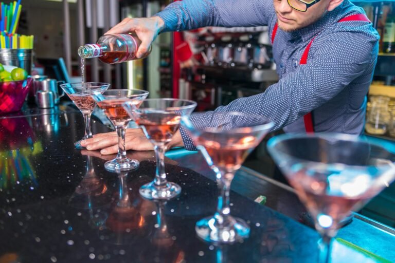 photo of man pouring liqueur on glass