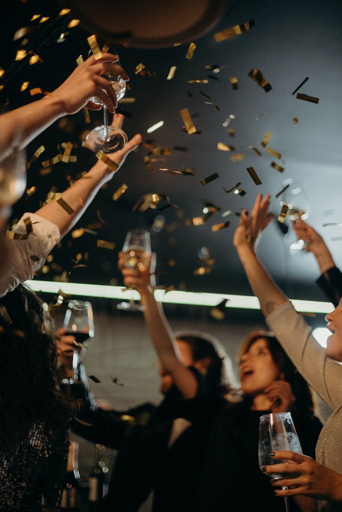 People enjoying a lively New Year's Eve party with champagne and confetti indoors.