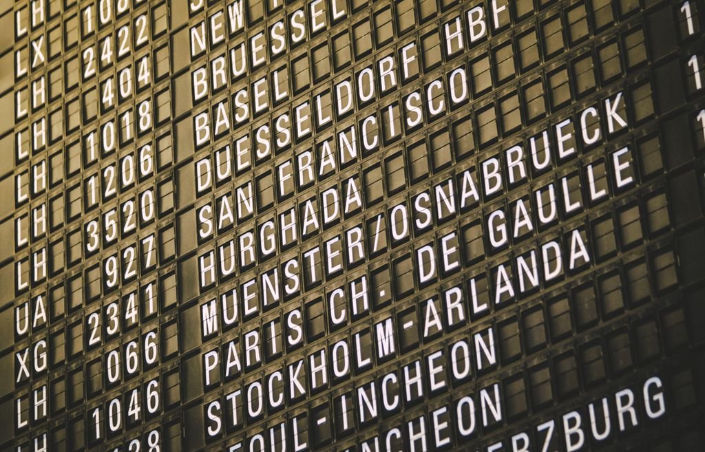 Close-up view of an airport departure board showcasing various international destinations.