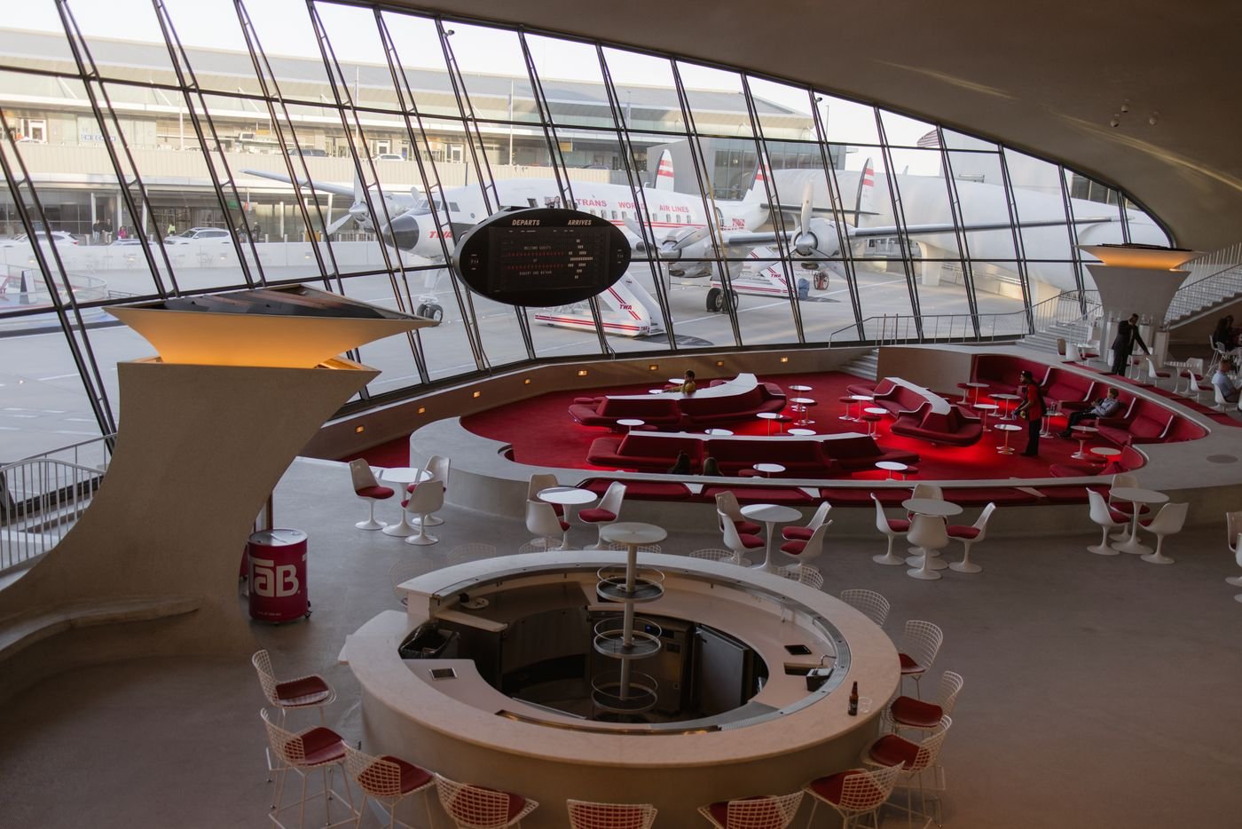 Aviation-inspired airport hotel interior with aircraft beyond the window